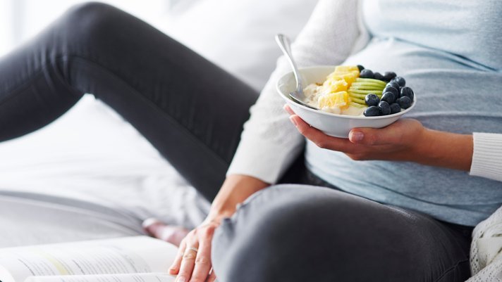 Mujer embarazada comiendo fruta